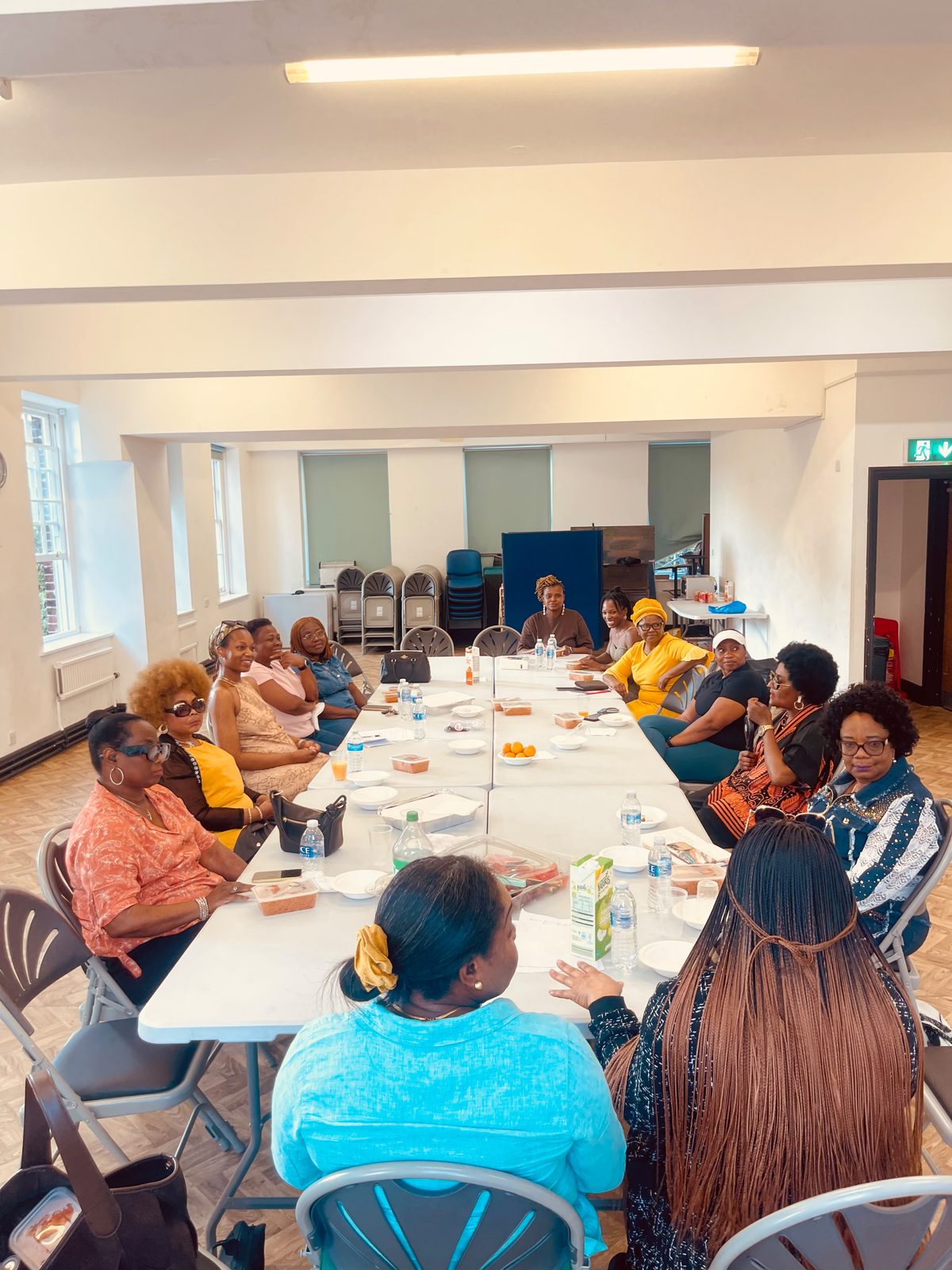 Women in conversation around a long table at a women-only Jollof Nights™